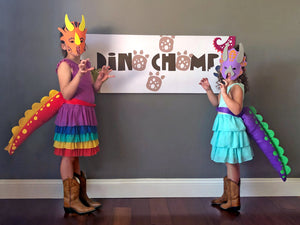 Dino chomp banner with kids dressed in dinosaur tails and masks