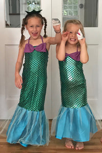 Children dressed in mermaid costumes with shark puppets