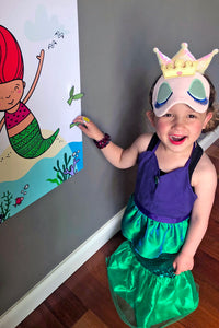 Child playing Pin the Fin on the Mermaid party game