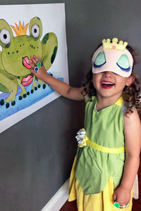 Child playing Pin the Kiss on the Frog at a princess party